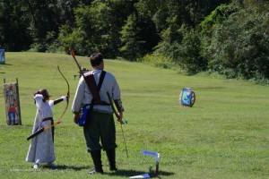 a parent and child shoot archery together at Battle on the Bay a parent and child shoot archery together at Battle on the Bay
